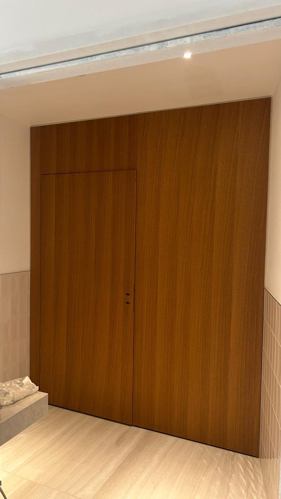 Boiseries toute hauteur et porte affleurante intégrée au parement.