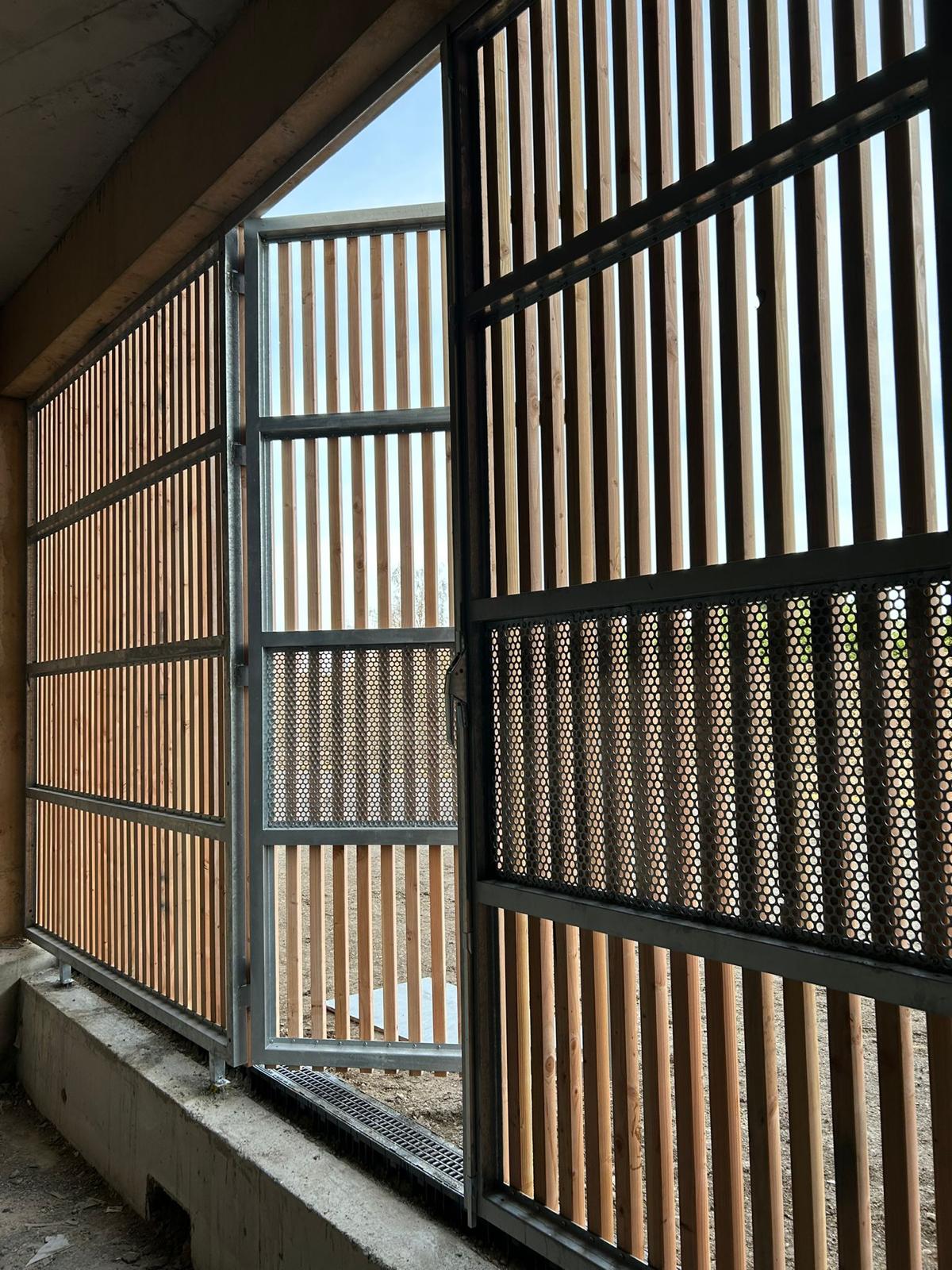 Claustra bois-métal : modules ouvrants pour l'accès et la ventilation.