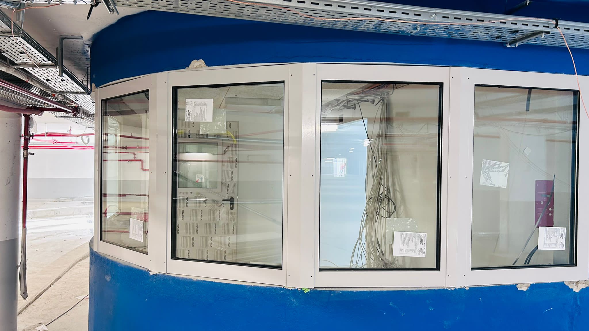 Châssis aluminium cintrés donnant sur les locaux techniques.